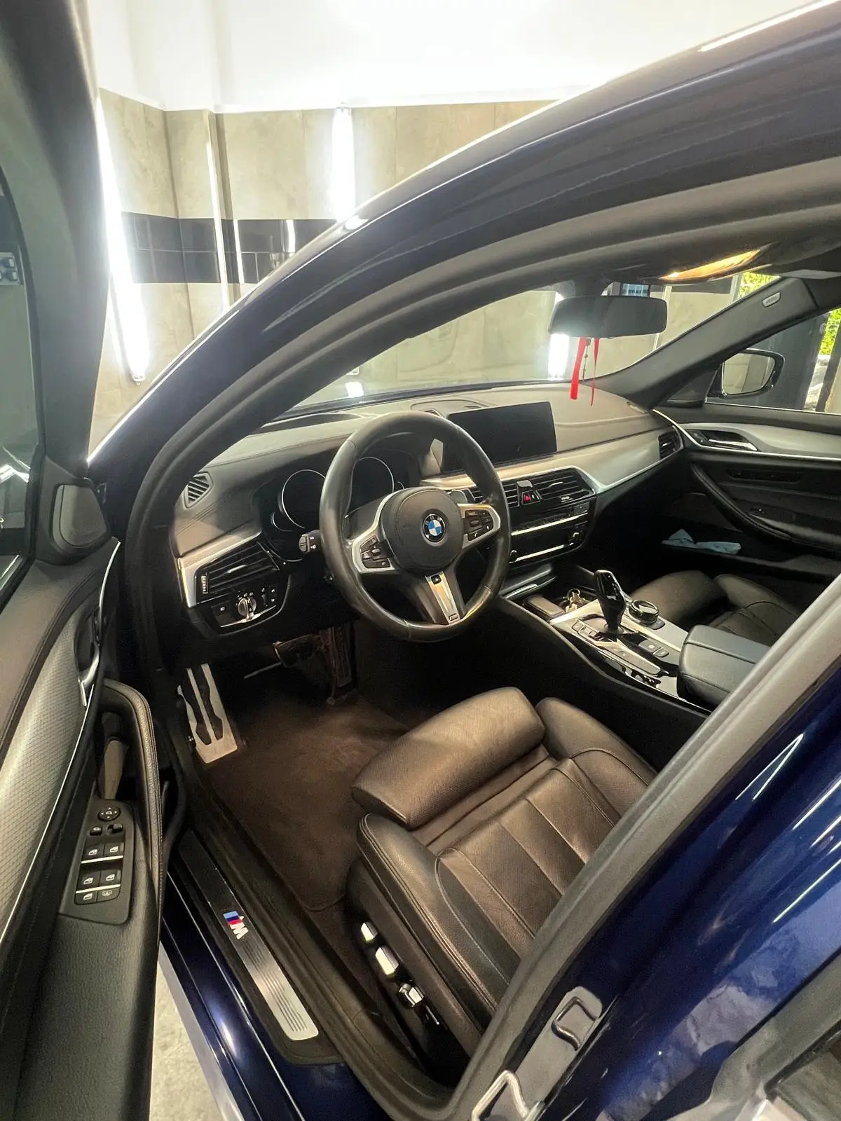 Realizacja: umyte BMW w garażu, widok wnętrza auta od strony kierowcy