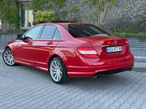 Czerwony Mercedes przygotowany do sprzedaży w myjni ręcznej - widok z ukosa na tył auta