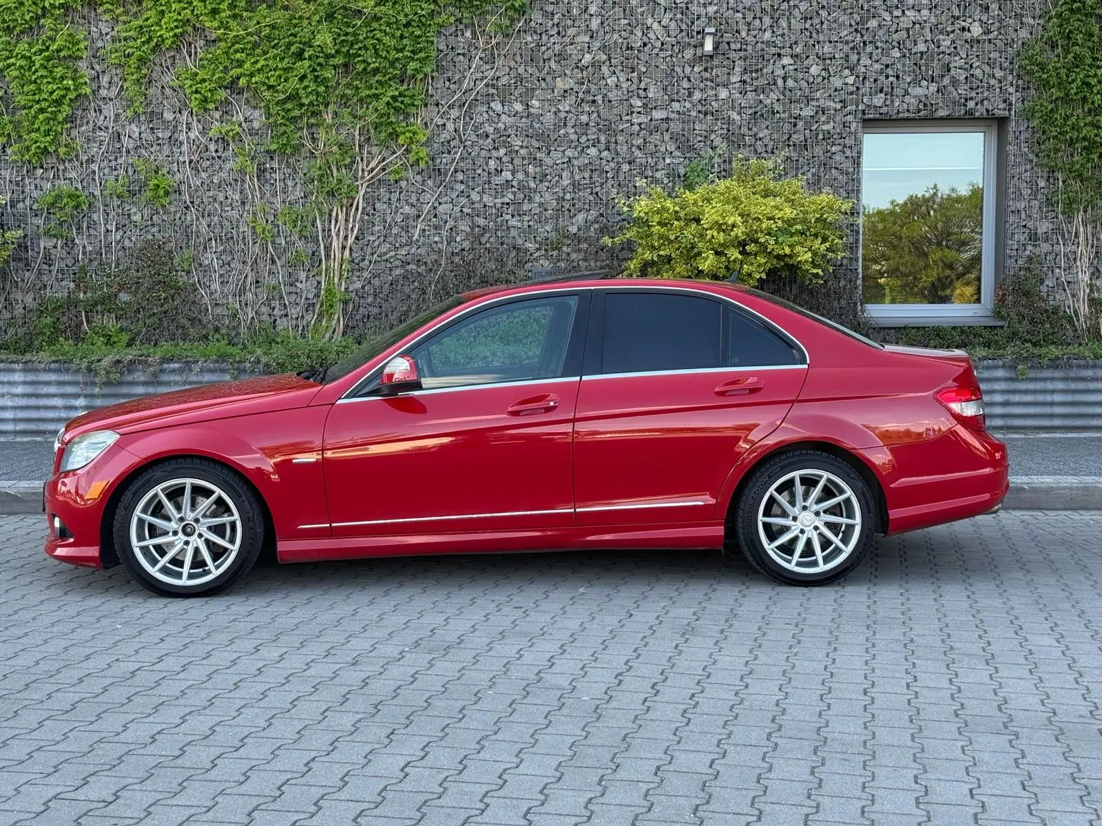 Czerwony Mercedes przygotowany do sprzedaży w myjni ręcznej - widok na auto z profilu