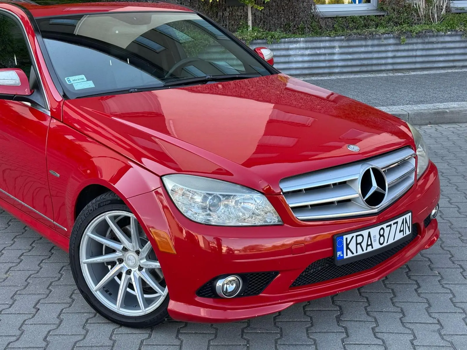 Czerwony Mercedes przygotowany do sprzedaży w myjni ręcznej - zbliżenie na przód auta