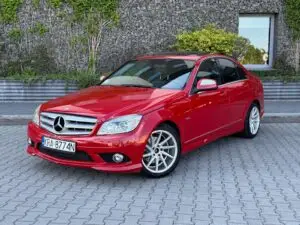 Czerwony Mercedes przygotowany do sprzedaży w myjni ręcznej - widok z ukosa na przód auta