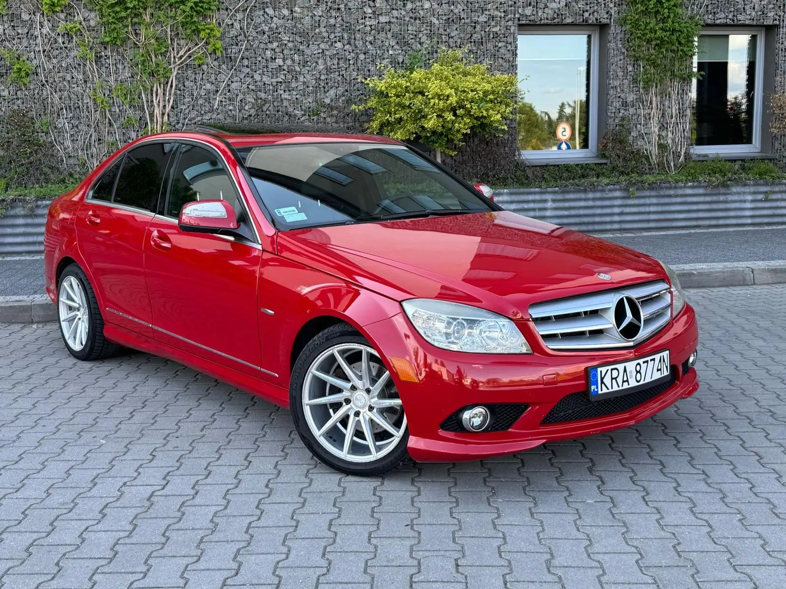 Czerwony Mercedes przygotowany do sprzedaży w myjni ręcznej - widok z ukosa na przód auta