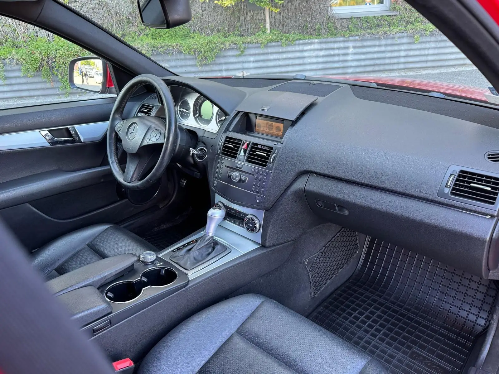 Czerwony Mercedes przygotowany do sprzedaży w myjni ręcznej - widok kokpit auta zza siedzenia pasażera