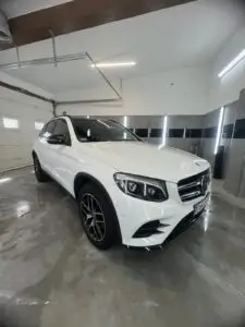 Biały samochód umyty z zewnątrz w myjni ręcznej - widok na auto z ukosa