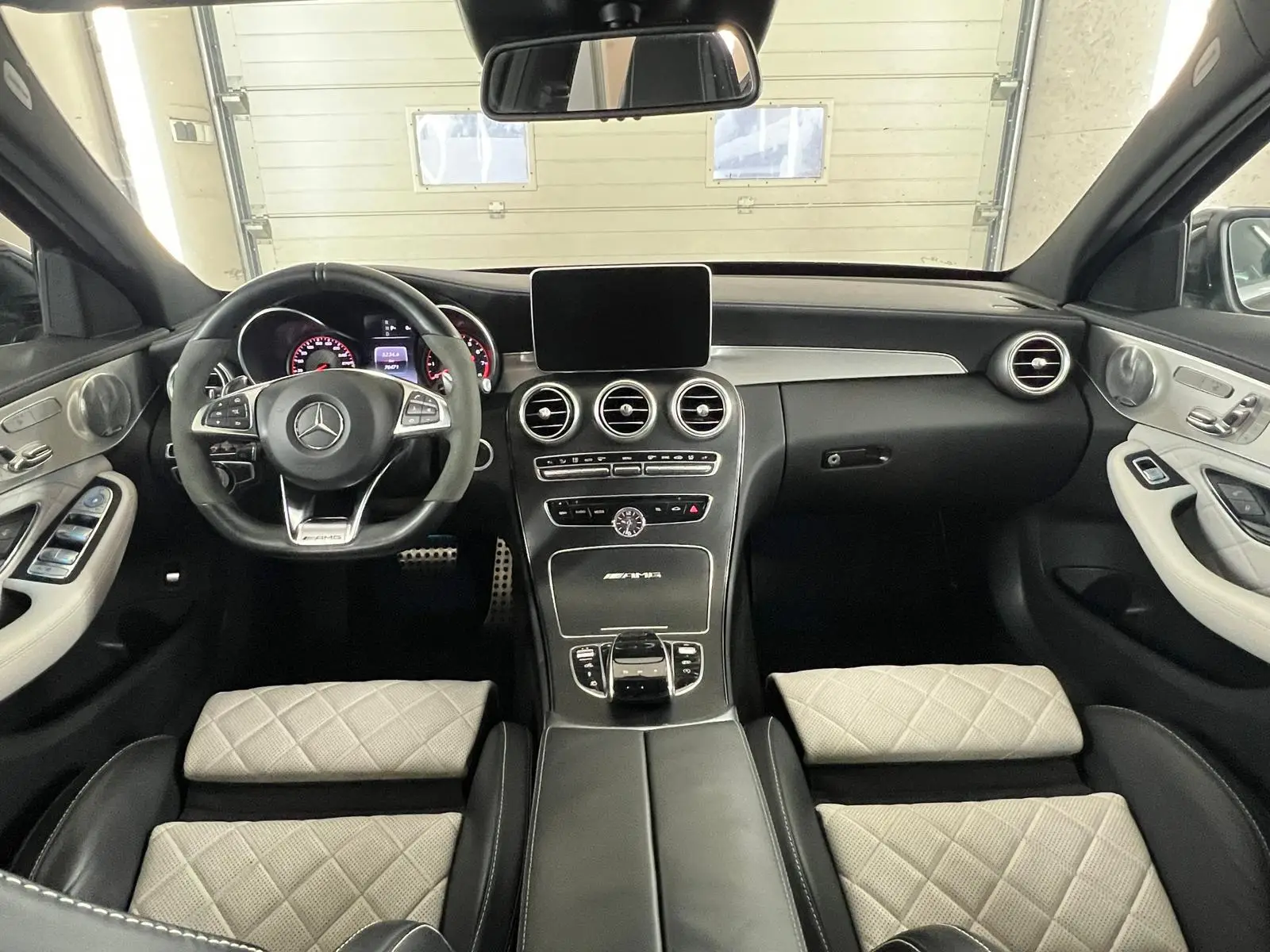 Mercedes z wnętrzem wyczyszczonym w myjni ręcznej - widok kokpit auta z tylnej kanapy