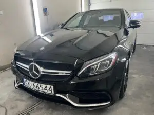 Czarny Mercedes wyczyszczony z zewnątrz w myjni ręcznej - widok z ukosa na przód auta