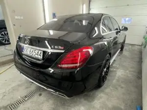 Czarny Mercedes wyczyszczony z zewnątrz w myjni ręcznej - widok z ukosa na tył auta
