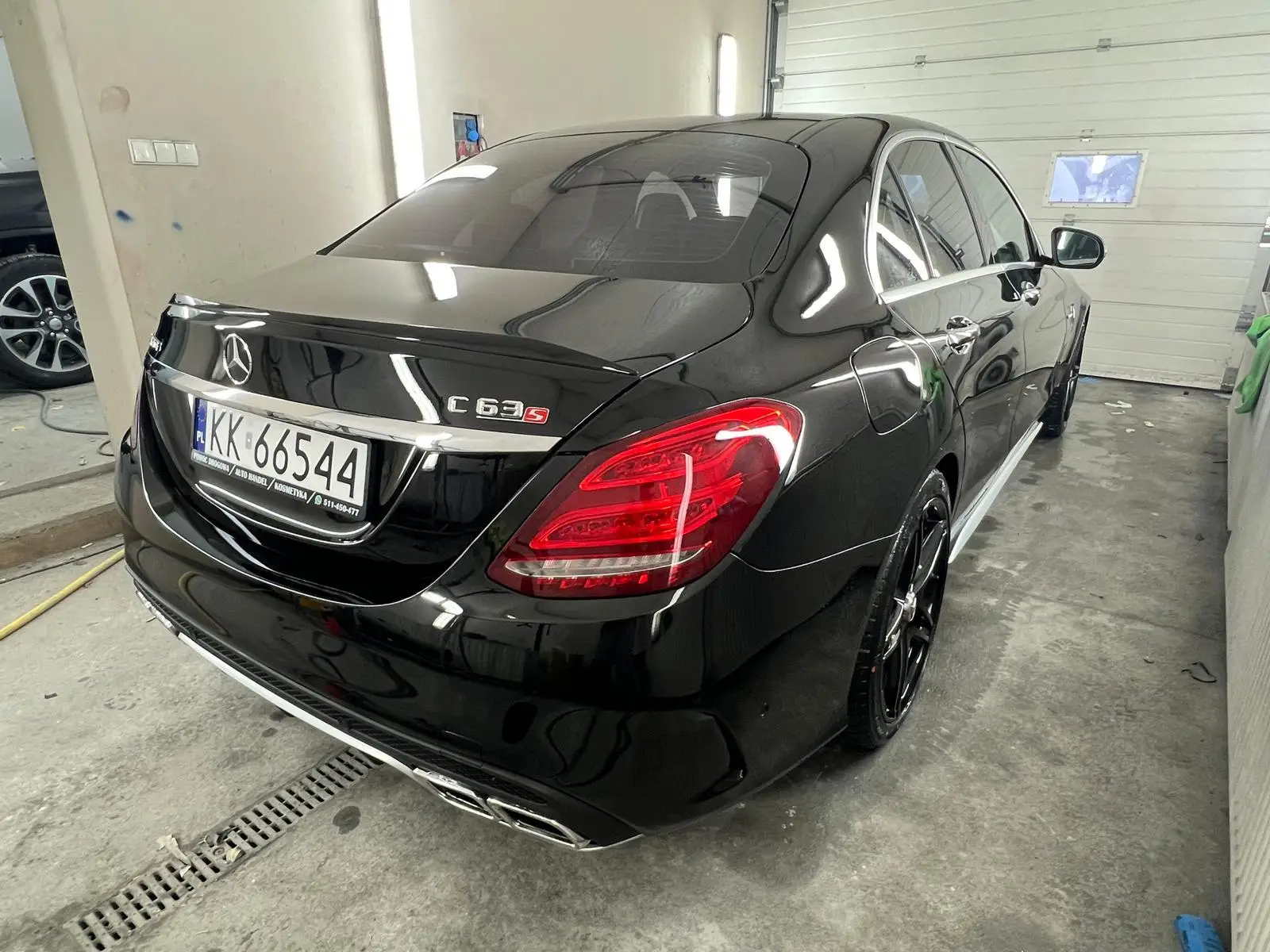 Czarny Mercedes wyczyszczony z zewnątrz w myjni ręcznej - widok z ukosa na tył auta